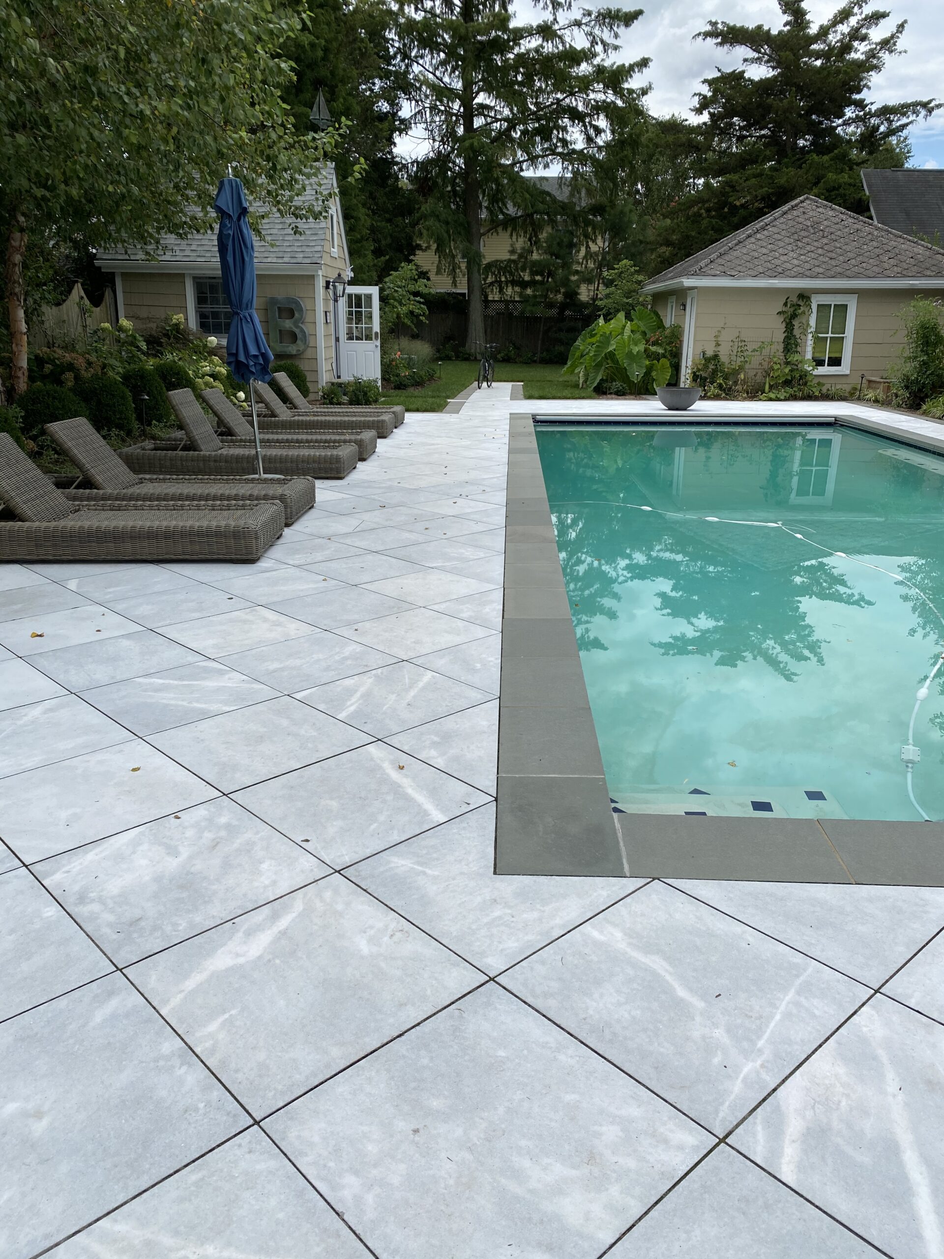 Poolside lounge chairs and paved outdoor living space