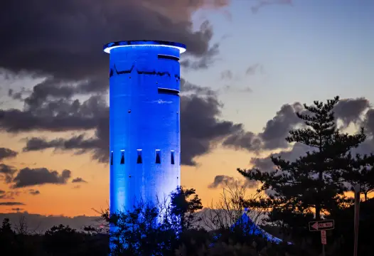 Tower illuminated in blue against a twilight sky